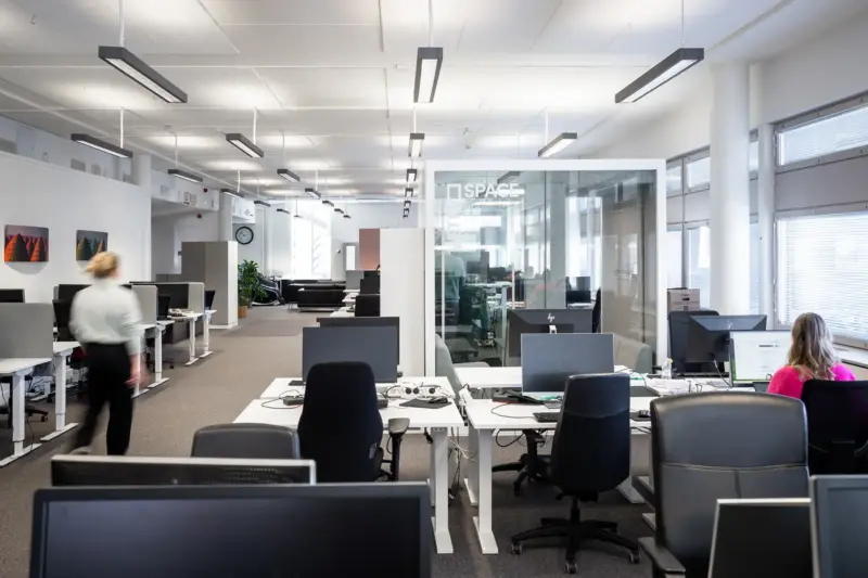 Open-plan office with a Vetrospace meeting pod and employees working at desks.